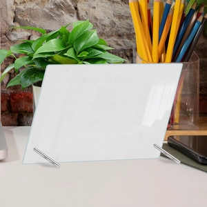 Macro shot of clear glass weekly planner on desk with metal supports and seven daily columns