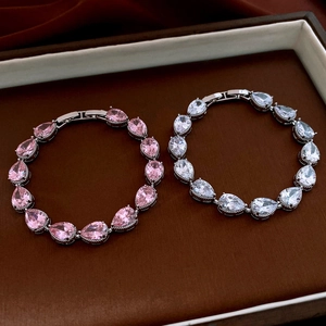 Close-up of pink and clear pear-cut zircon bracelets with silver clasp on velvet tray