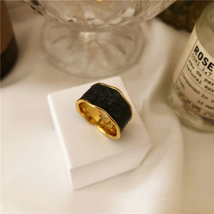 Detail of s925 silver ring with cream enamel and gold trim on white display pedestal