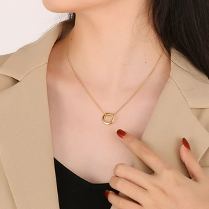 Minimalist gold geometric round triple loop pendant necklace worn on a model's neck