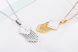 Detail of gold and silver tassel necklaces with faux marble inlay and crystals
