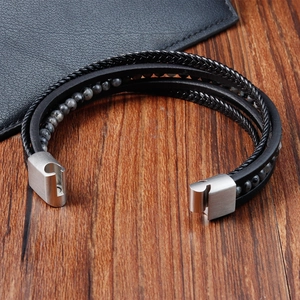 Detailed close-up of multilayer black leather woven bracelet with magnetic metal clasp