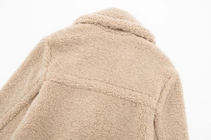 Macro detail of khaki faux shearling fleece texture and stitching on the oversized coat