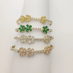 Detail of four golden clover bracelets featuring colorful marquise gemstones and small diamonds