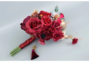 Detailed close-up of a Chinese wedding bridal bouquet with red roses and gold leaf accents