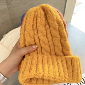 Close-up of ginger yellow chunky cable knit winter beanie showing soft texture