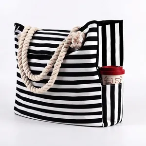 Detail of nautical striped canvas tote bag showing side pocket holding a coffee tumbler