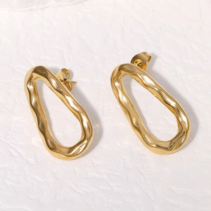 Golden irregular oval earrings with hammered texture finish in minimalist style