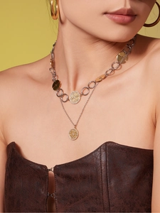 Close-up of double-layer gold and silver mixed metal necklace with round textured pendants