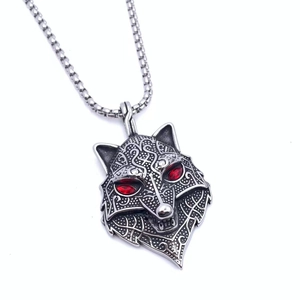 Detail of silver wolf head pendant with red gemstone eyes and matching metal chain