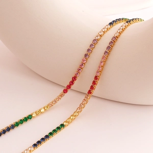 Elegant gold tennis necklace with rainbow gradient cubic zirconia on white display