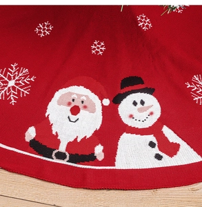 Détail du tapis de sapin de Noël tricoté rouge avec motifs Père Noël, bonhomme de neige