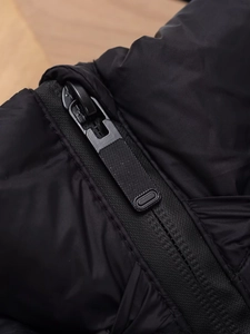 Gros plan détaillé de la fermeture éclair et du tissu mat d'un gilet rembourré noir