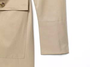 Primer plano de costuras de bolsillos y botones oscuros en vestido mini kaki
