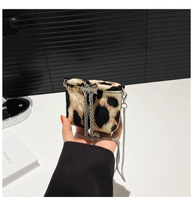 Detail view of mini leopard print crossbody bag featuring silver chain strap and drawstring