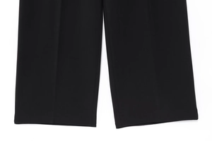 Gros plan détaillé de l'ourlet large et de la texture tissée du pantalon noir