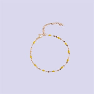 Detail of gold lip chain bracelet with yellow enamel beads and adjustable lobster clasp