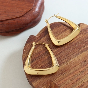 Polished 18k gold plated U-shaped geometric earrings on elegant wooden stands