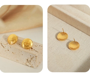 Macro shot of gold-plated titanium earrings with irregular round water ripple texture