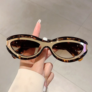 Detail of tortoiseshell cat-eye sunglasses featuring golden metallic trim on the frame