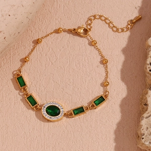 Detail showing 18K gold-plated bracelet with emerald green zircon stones and white crystals