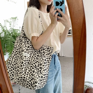 Detail of leopard print canvas tote bag shown in a stylish lifestyle mirror selfie