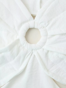 Détail de robe blanche sans manches montrant le tissu tissé texturé et l'anneau découpé