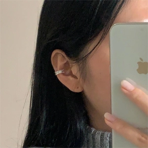 Close-up of a minimalist silver ear cuff with rectangular zircon stones on ear