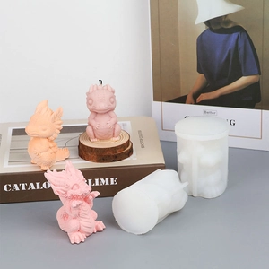 Molde de silicona de dragón detallado con velas aromáticas rosas en un escritorio
