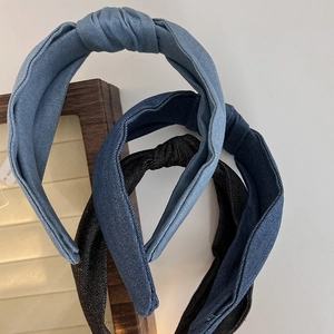 Detailed view of three knotted denim headbands in light blue, medium blue and dark grey