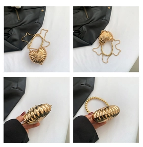 Detail view of a gold heart-shaped metallic handbag with ribbed texture and beaded chain
