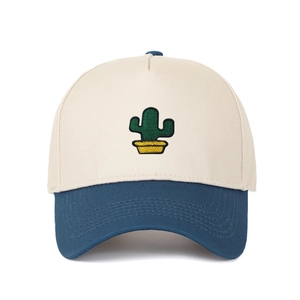 Détail de la broderie cactus sur une casquette de baseball bicolore crème et bleu marine