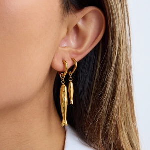 Elegant gold fish-shaped stud earrings for women shown worn on a model ear