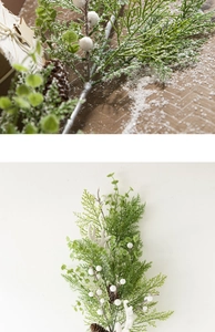 Close-up of frosted Christmas garland with green leaves, pine cones and white berries