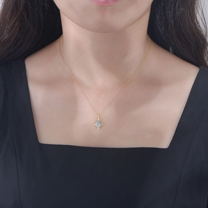 Teardrop sky blue topaz pendant on 925 silver gold chain worn on a model's neck
