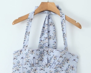 Close-up of light blue floral bee print halter top with lace trim and button details