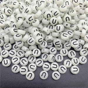 Macro shot of white acrylic letter U beads with side holes for DIY jewelry making