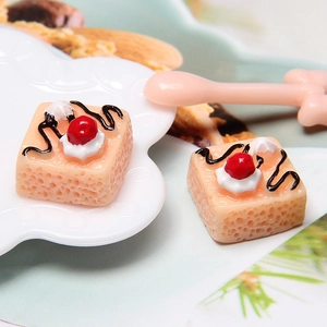 Detailed view of yellow resin miniature cakes with white cream and red berry toppings