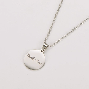 Macro shot of silver stainless steel necklace pendant engraved with Family First
