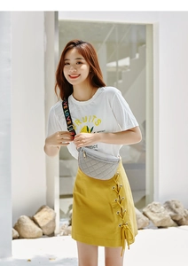 Outdoor shot of a grey quilted fanny pack with colorful LOVE letter straps on a model