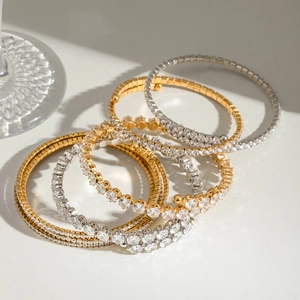 Detailed view of layered stainless steel bangles with sparkling cubic zirconia in gold and silver