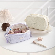 Quilted cosmetic bags in purple and cream fabric featuring internal compartments and storage