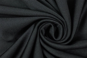 Close-up of black knitted fabric showing fine texture and elastic ribbing detail
