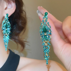Close-up of long green zircon tassel earrings with gold-plated drop pendant design