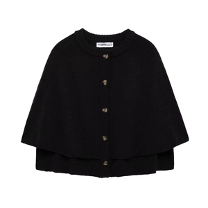 Detail of black knit poncho cardigan featuring amber-toned buttons and ribbed texture