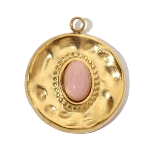Detailed close-up of a gold hammered metal pendant with an oval pink natural stone