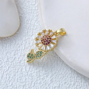 Golden rose pendant necklace with colorful sparkling crystals on white marble background