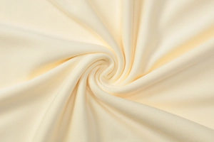Macro view of cream knitted fabric showing detailed ruched texture and soft draping
