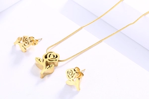 Detailed view of golden rose pendant on snake chain with matching flower earrings