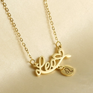 Close-up of 18k gold Leo zodiac pendant on silk background showing fine details